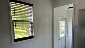 A room with a window, a door, and a vent. - Charming Algoma retreat - 10 min. Walk to the Beach (Algoma)