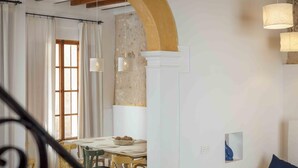 A dining area with a wooden table, chairs, and hanging pendant lights.