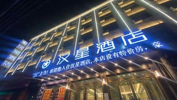 Un hotel con señalización iluminada y fachada moderna.