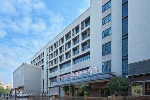 Un moderno edificio de hotel con varios pisos y una entrada destacada.