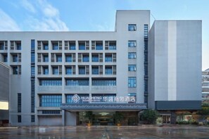 A modern building with a flat facade, multiple windows, and a prominent entrance. - Huasheng Business Hotel (Foshan)