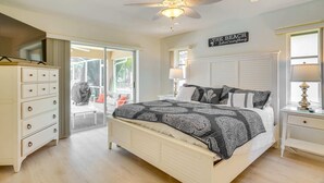 A bedroom with a bed, a dresser, a ceiling fan, and a window. - Holly's HomeAway-Private Pool, Kayaks & Canal Adventures (Cape Coral)