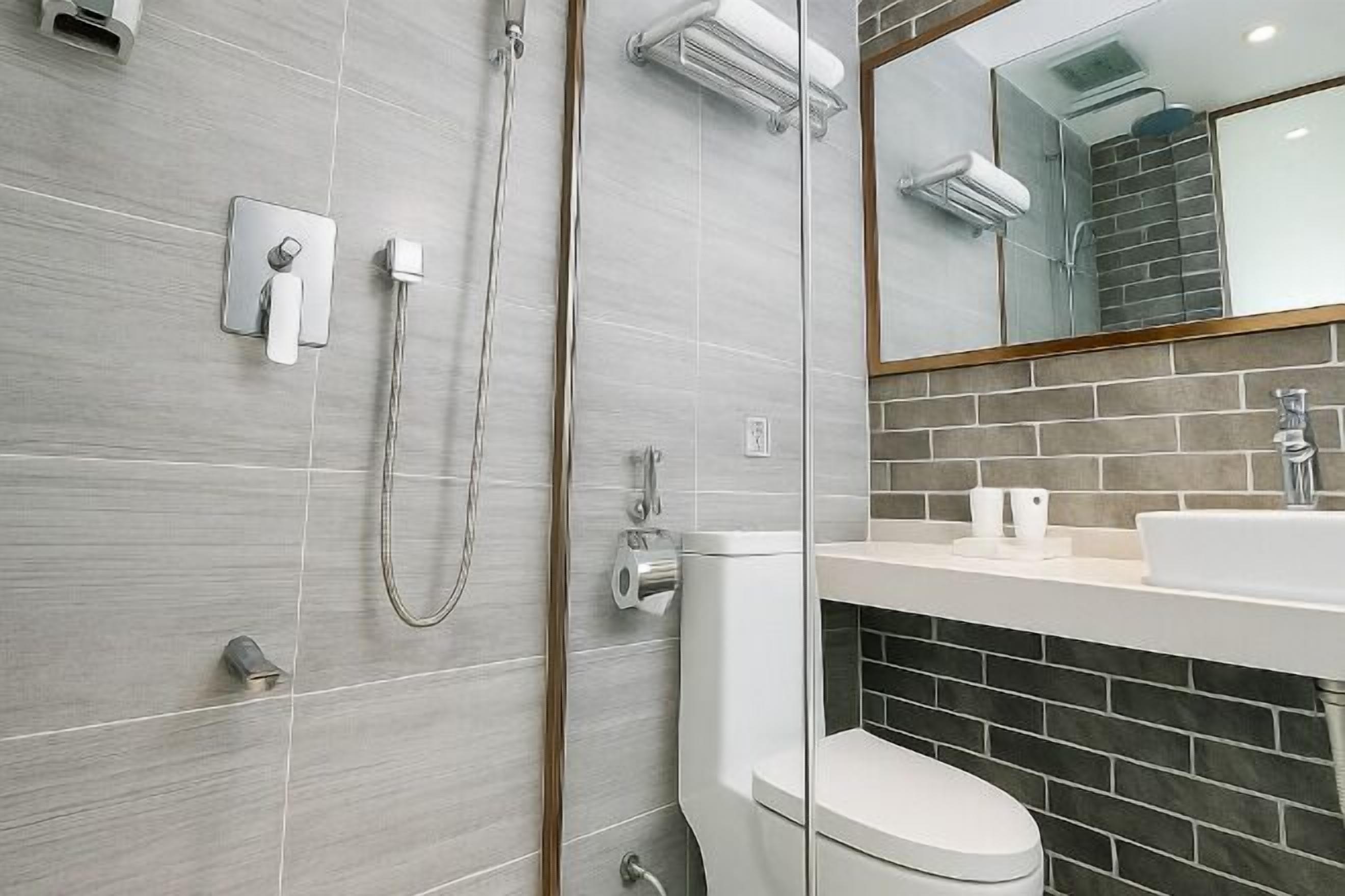 Een moderne badkamer met douche, toilet en wastafel.