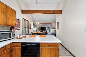 A kitchen with wooden cabinets, a built-in microwave, and a dishwasher.