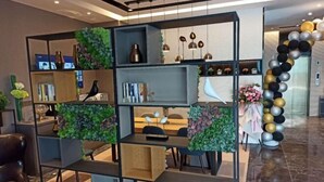 A modern reception area with a black and white balloon arch, a wooden reception desk, and green plant decorations on shelves. - Homeinn Selected Hotel (Zhengzhou Huayuan Road Grand Emporium) (Zhengzhou)