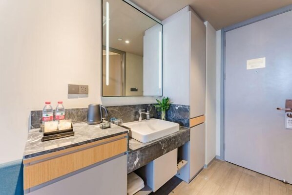 A modern bathroom with a marble countertop, a sink, a mirror, and a door. - Homeinn Selected Hotel (Zhengzhou Huayuan Road Grand Emporium) (Zhengzhou)
