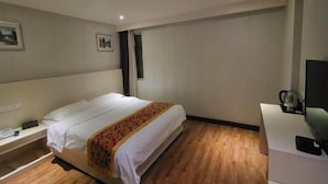A hotel room with a bed, bedside table, and a television. - Yuanke Hotel (Chibi)