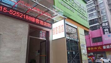 A hotel entrance with a signboard, a visible door, and a window with a view.