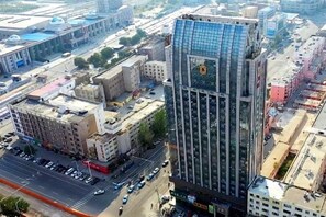 A high-rise building with a modern glass facade, surrounded by other buildings and a busy street. - Super 8 Hotel (Tongliao Railway Station Jianguo Road) (Tongliao)
