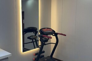 A stationary exercise bike with a digital display, positioned in a room with a large mirror reflecting the bike. - Super 8 Hotel (Tongliao Railway Station Jianguo Road) (Tongliao)