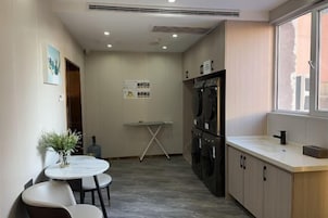 Una cocina compacta con horno integrado, un lavamanos y un ventanal.