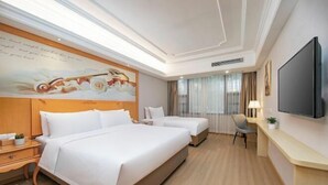 A hotel room with a large bed, a smaller bed, a desk, and a television. - Vienna International Hotel (Fuzhou)