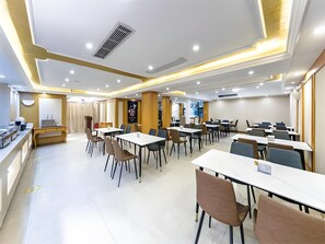 A modern conference room with multiple tables and chairs, equipped with ceiling lights and ventilation. - Vienna International Hotel (Fuzhou)