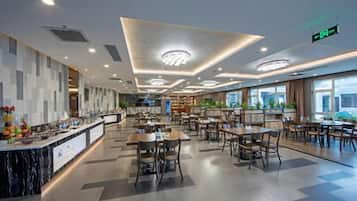 Un comedor moderno con barra de mármol, diversas opciones de asientos e iluminación empotrada en el techo.