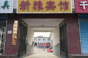 A hotel entrance with a signboard, a gated entrance, and a building in the background. - Yuanping Xinya Hotel (Yuanping)