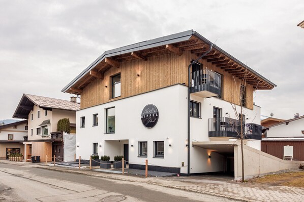 Un edificio moderno con facciata in legno, un balcone e un cartello con su scritto