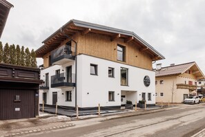 Un edificio moderno su due piani con facciata in legno e un balcone.