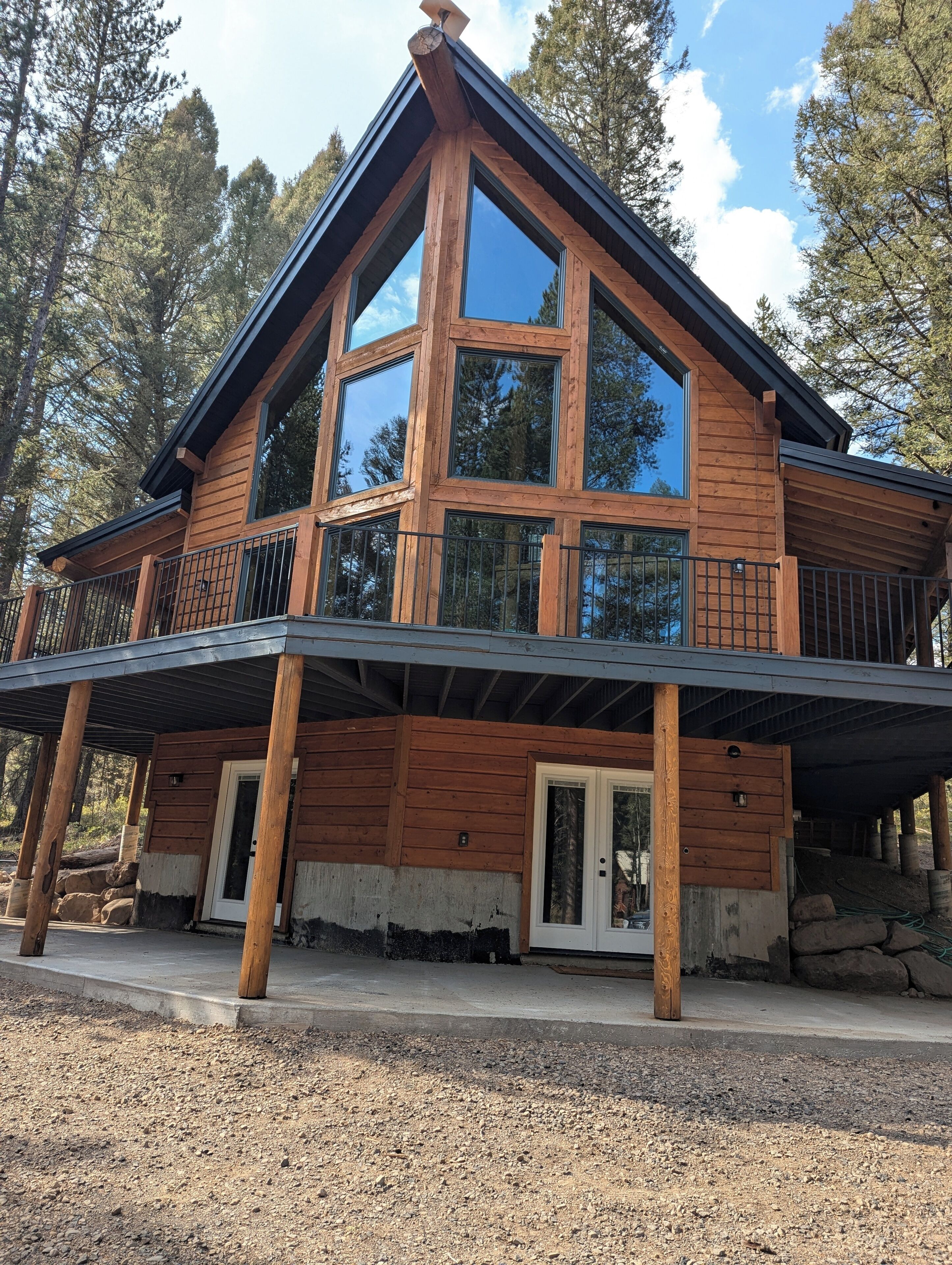 Front of cabin, large windows and beautiful mature trees. 