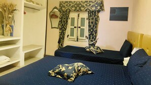 Une chambre avec deux lits, une armoire et un miroir.