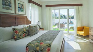 Une chambre d’hôtel avec un grand lit, une chaise et une vue sur une piscine et un espace verdoyant.