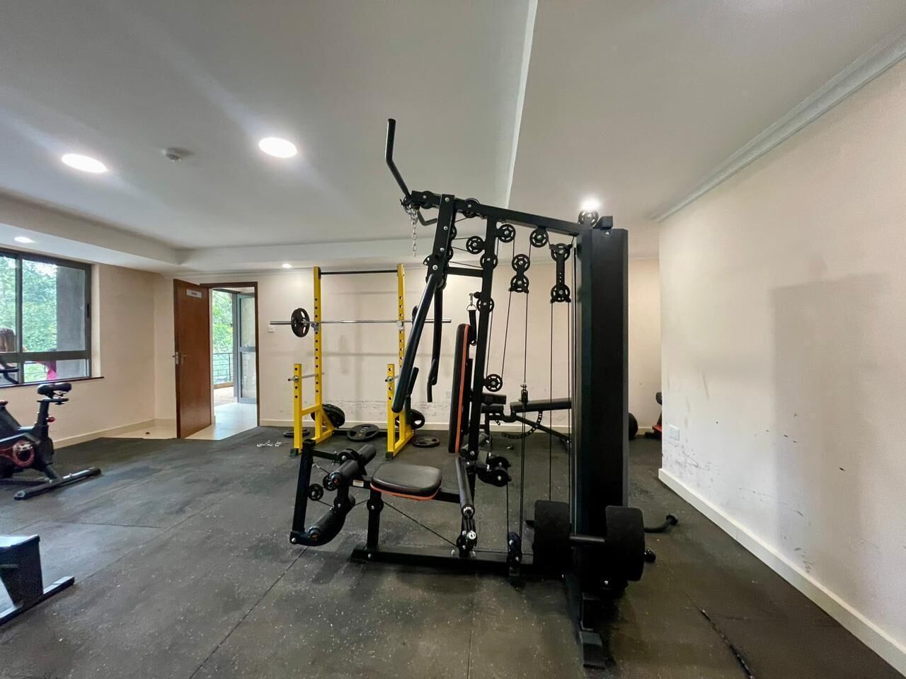 A gym with weightlifting equipment, a bench, and a treadmill.