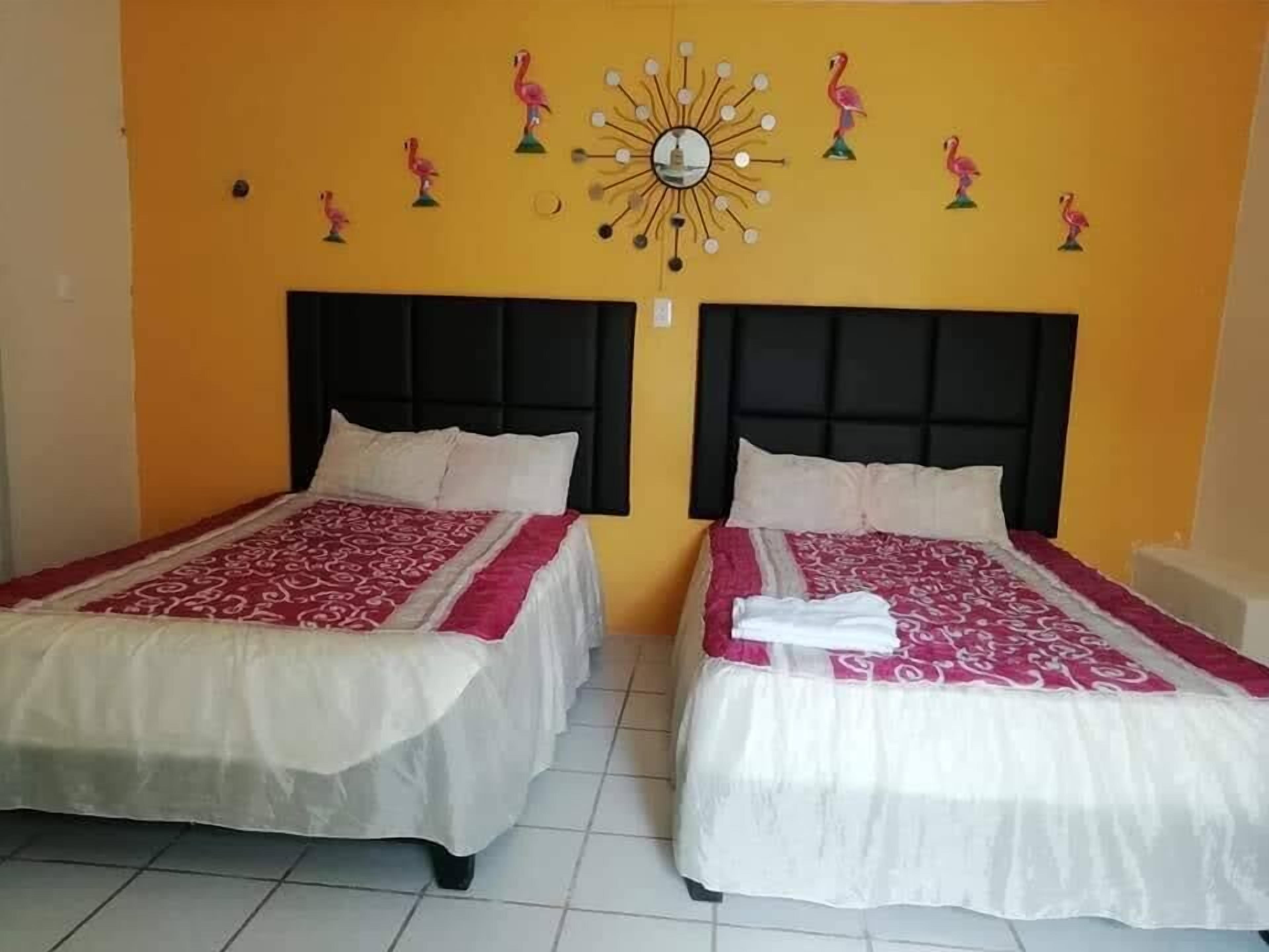 A hotel room with two beds, each with a black headboard and white bedding.
