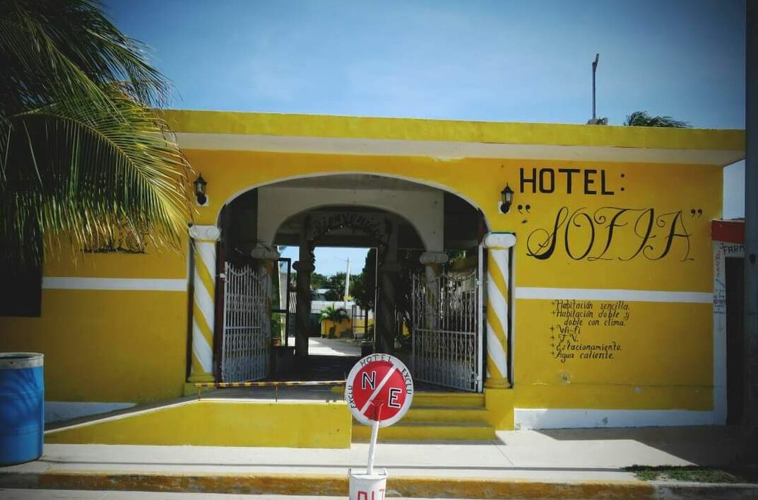 A yellow building with a sign that reads "HOTEL: SOFFA" and a sign prohibiting entry.