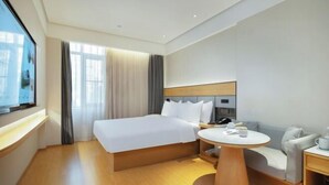 A hotel room with a bed, a round table, a sofa, and a TV. - JI Hotel (Fuzhou Yantaishan Park Shangsan Road) (Fuzhou)