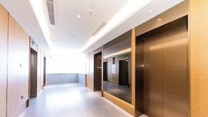 A modern hotel corridor with elevators and doors on both sides. - JI Hotel (Fuzhou Yantaishan Park Shangsan Road) (Fuzhou)