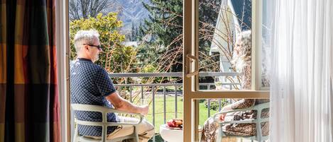 A room with a view of a mountainous landscape through a large window.