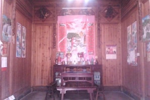 A room with wooden walls and a traditional Japanese-style interior. There are wooden tables and chairs, a decorative screen, and various posters on the walls. - Qingyuan Renjia Inn (Wuyuan)