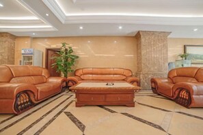 A lobby with leather sofas, a central coffee table, and a potted plant. - Chongqing Ba Bai Feng Traders Hotel (Chongqing)
