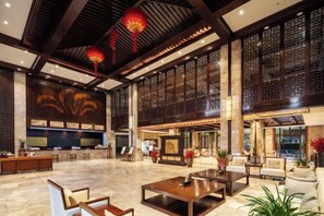 Un hall amplio con mostrador de recepción, zona de estar y detalles decorativos.