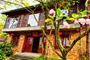 Un edificio tradicional con fachada de piedra, balcones de madera y puerta de entrada roja.