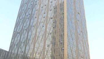 A tall building with a distinctive geometric facade, featuring a pattern of diamond shapes and a grid-like structure.