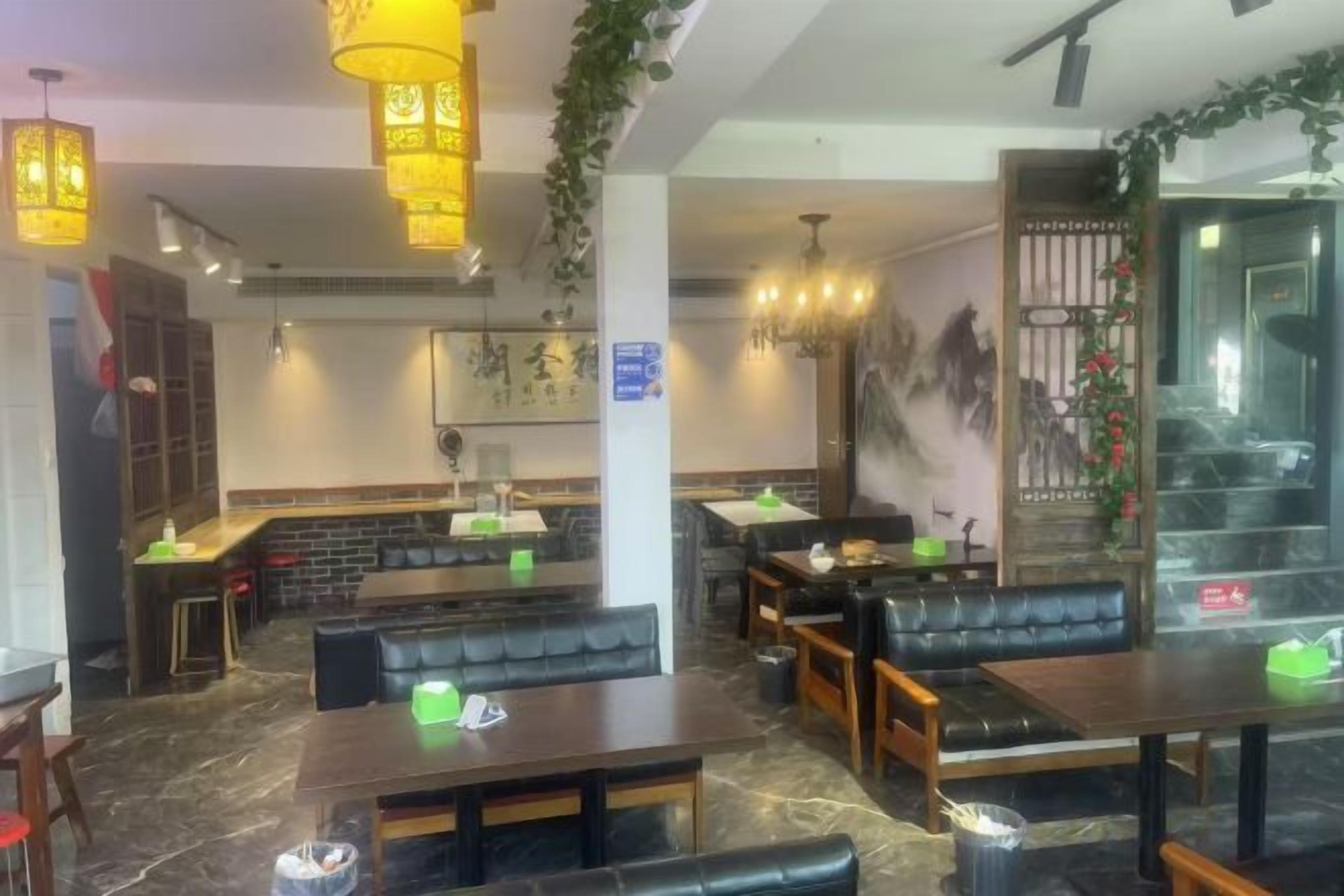 A restaurant interior with booths, tables, hanging lights, and a counter.