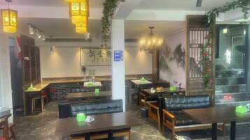 A restaurant interior with booths, tables, hanging lights, and a counter.