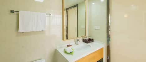 A modern bathroom with a white sink, a mirror, and a towel rack.