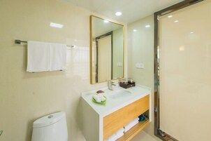 Un baño moderno con un lavamanos blanco, un espejo y un perchero para toallas.