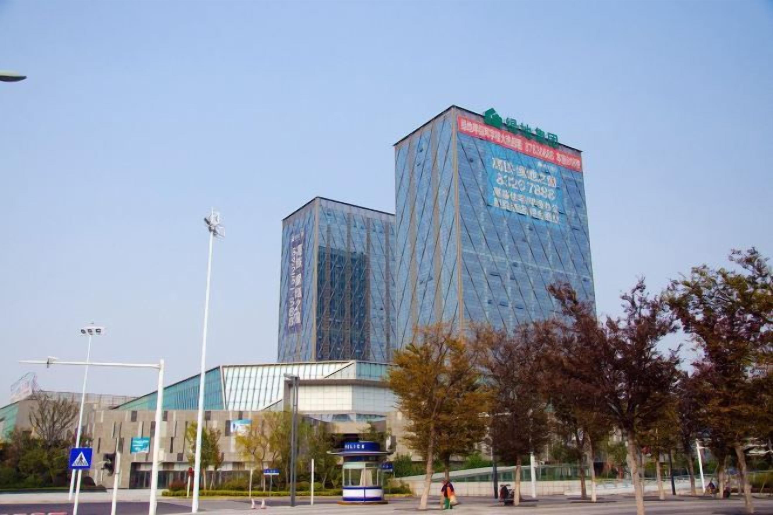 Un edificio moderno con fachada de vidrio y señalización que indica que es un hospital.