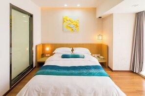 A hotel room with a bed, bedside tables, a painting on the wall, and a window with curtains. - Ginkgo Hotel (Xuzhou)