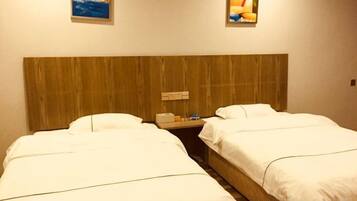 A hotel room with two beds, a wooden headboard, and artwork on the walls.