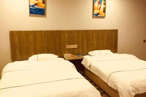 Ein Hotelzimmer mit zwei Betten, einem Holzkopfstück und Kunstwerken an den Wänden.