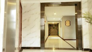 Una hall d'albergo con pavimento in marmo, una reception e una targa appesa al muro.
