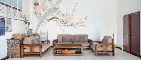 A living room with a sofa set, a coffee table, and a wall mural.