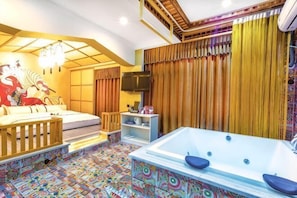 A room with a large bathtub, a sofa, a television, and a patterned floor.
