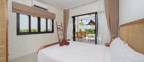 Une chambre d’hôtel avec un grand lit, une fenêtre avec des stores, un balcon avec une chaise et une échelle en bois.
