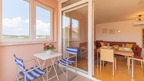 Un balcon avec une table et des chaises, un canapé et une vue sur le paysage.