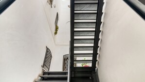 A staircase with a black handrail and metal balusters, leading to a landing with a potted plant. - GuestHost - Cozy apartment of 80 sqm, on two levels, for 2 people, located on the 1st floor of a building with lift (steps to access: not suitable for disabled people).The property is located in the heart of the historic center of Palermo (Restricted Tra (Palermo)