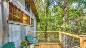 A wooden deck with two green chairs and a small table, overlooking a forested area. - Unique Eureka Springs Cabin: Deck & Forest Views! (Busch)